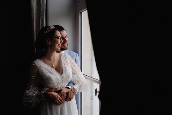 couple de mariés qui regardent par la fenêtre